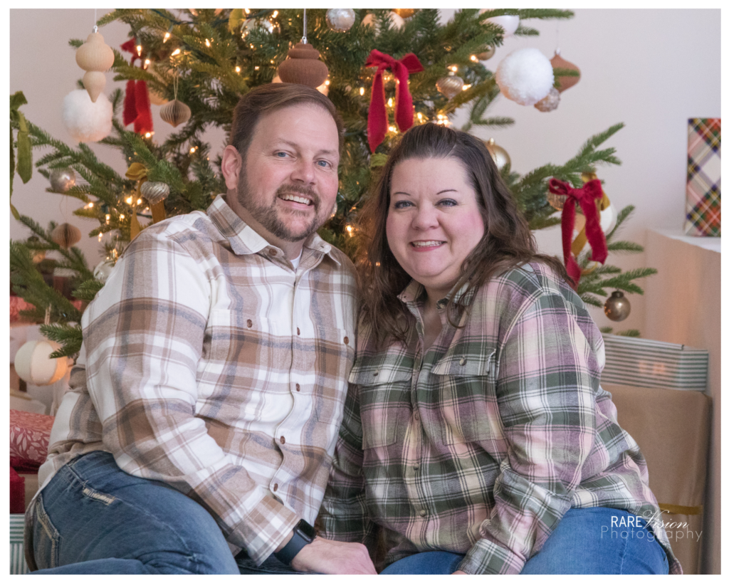 Image of couple in front of Christmas tree