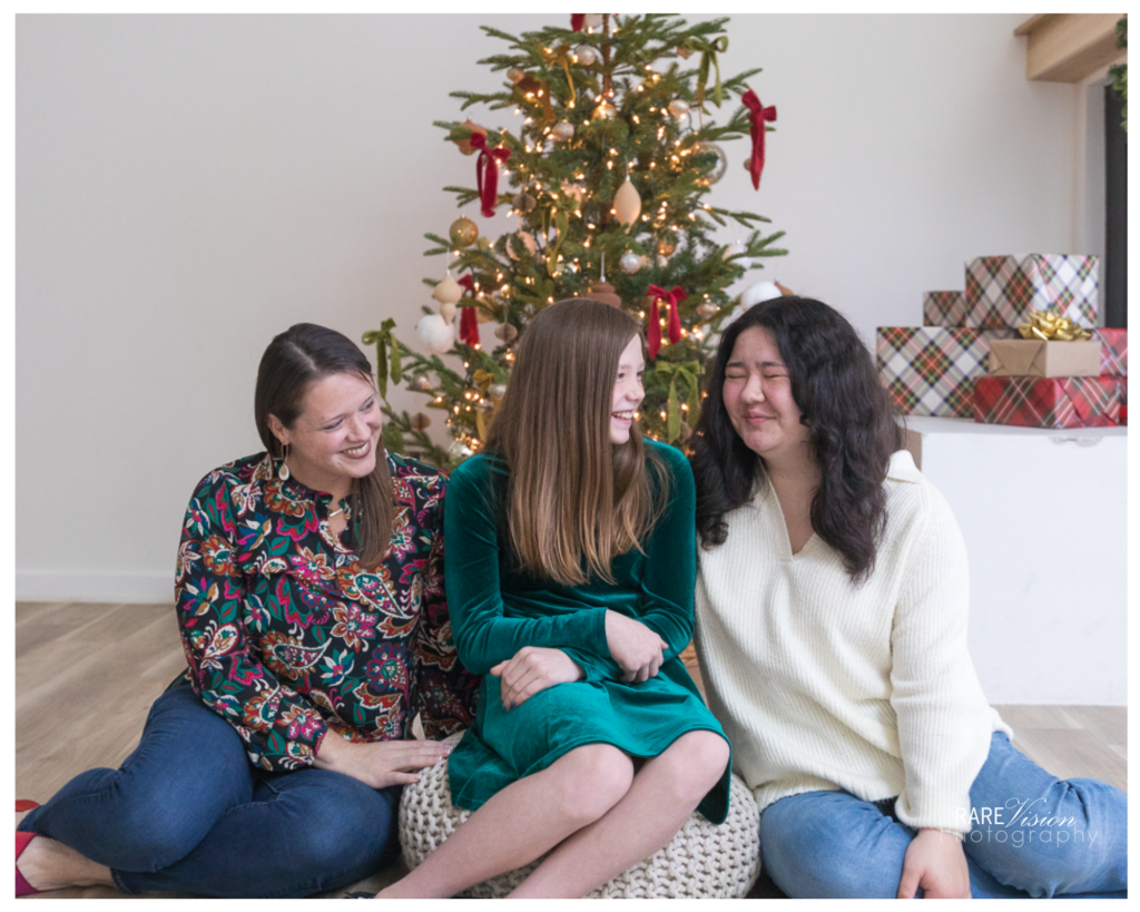 Image of mom and daughters in front of Christmas tree