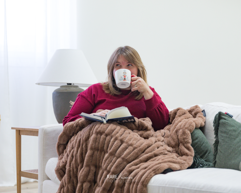 Image of photographer reading and sipping a hot drink