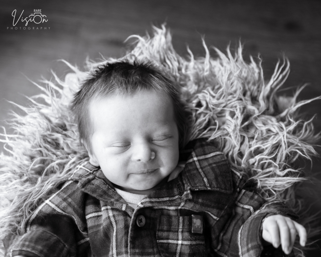 Image of newborn sleeping and smiling