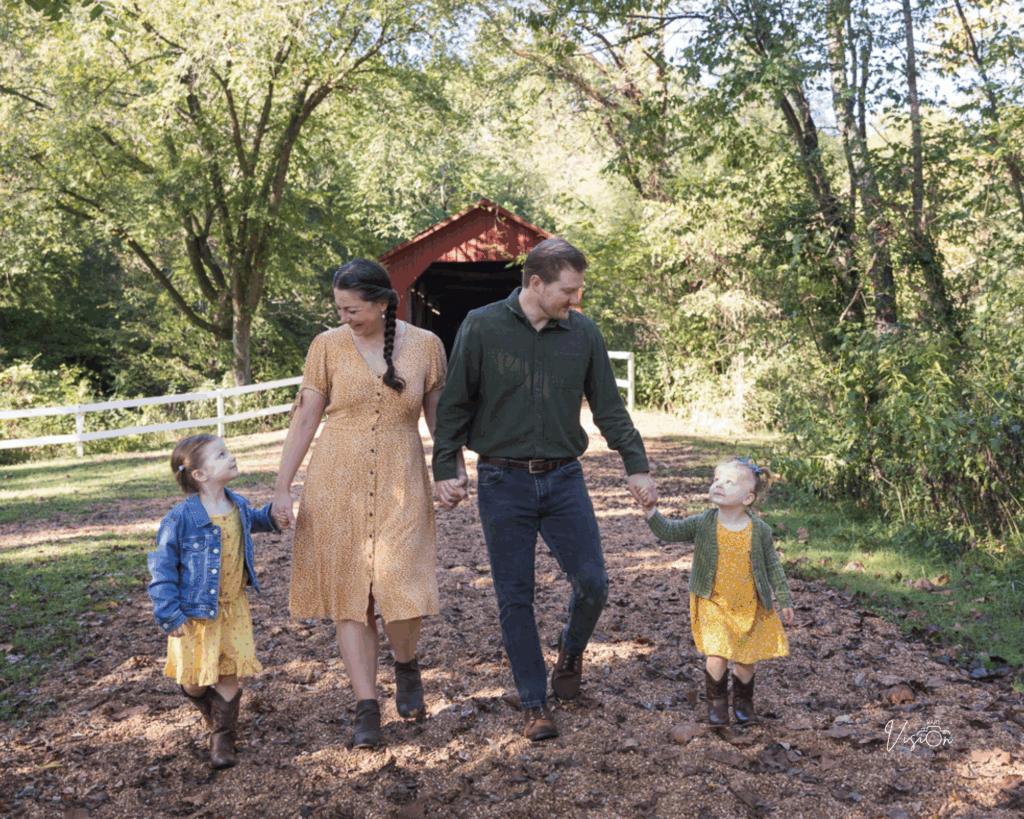 Image of young family walking hand-in-hand.