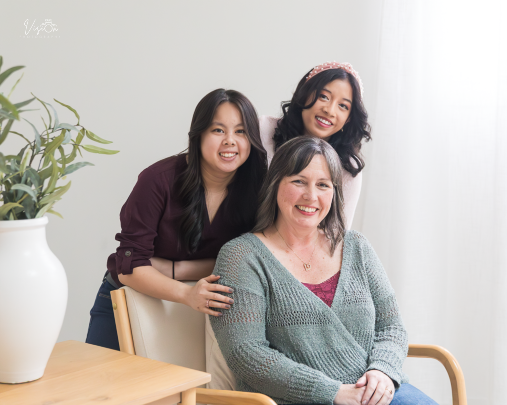 Image of adult daughters with mom all looking at camera
