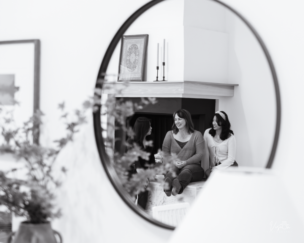 Image of mom and daughters talking taken from a mirror