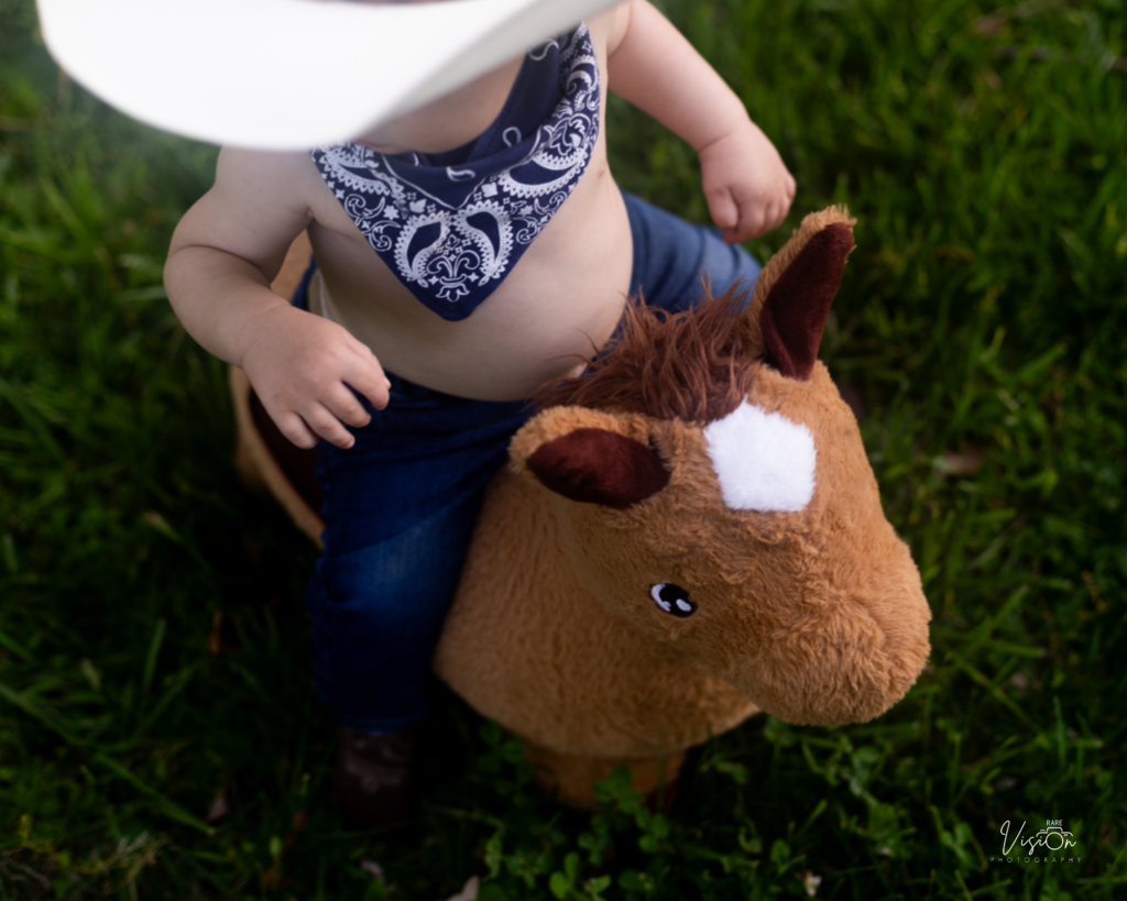 Image of one year old on toy horse